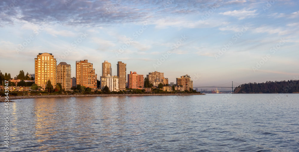 Fototapeta premium Walking Trail in a modern city on the West Coast of Pacific Ocean. West Vancouver Centennial Seawalk, British Columbia, Canada. Sunny Summer Sunset.