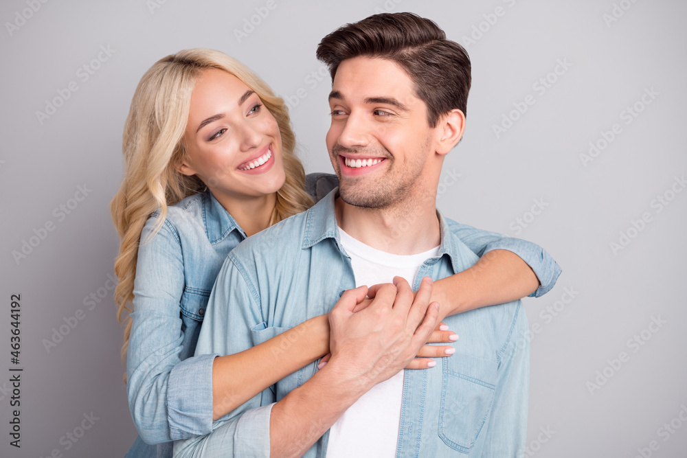 Photo of young couple happy positive smile embrace love feelings spouses isolated over grey color background Photo of young couple happy positive smile embrace love feelings spouses isolated over grey color background