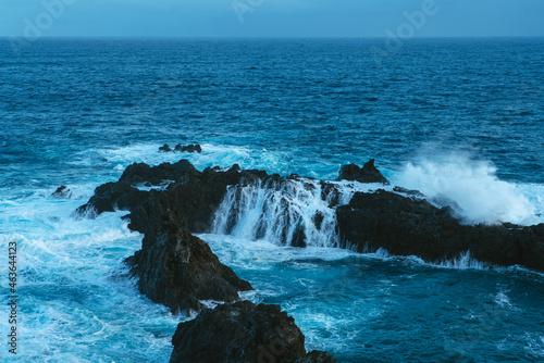 view at the dramatic landscape with volcanic cliffs and water splashes, dark Atlantic ocean coastline, Charco del Viento