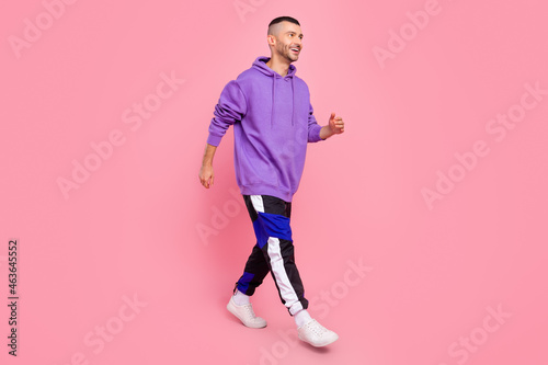 Full size profile side photo of young sportsman go walk look empty space isolated over pink color background