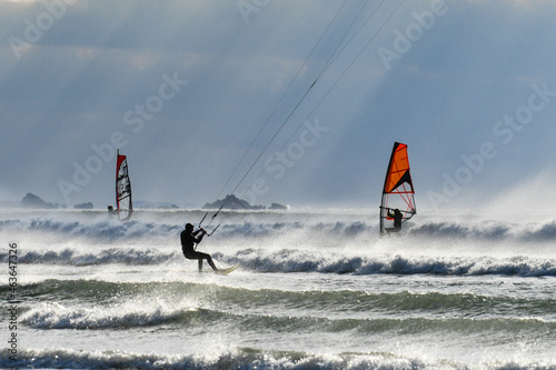 Kitesurf et windsurf se partagent les vagues sous une belle lumière