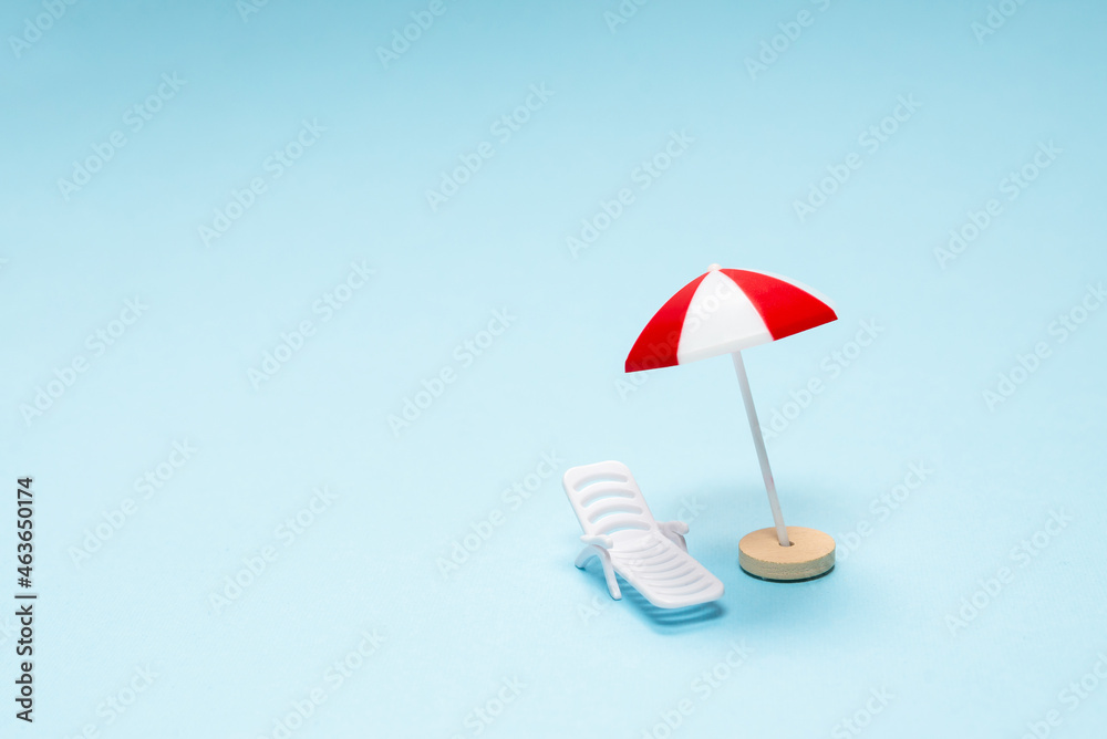 Travel concept. Sun lounger, red umbrella on a blue background.