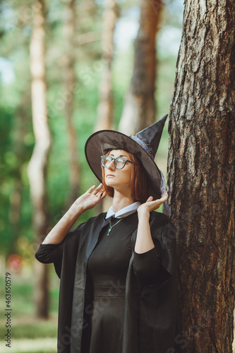 Obraz na płótnie Halloween Witch. Portrait of a girl in a hat and a witch costume in the forest. Ready for trick or treat holiday
w salonie