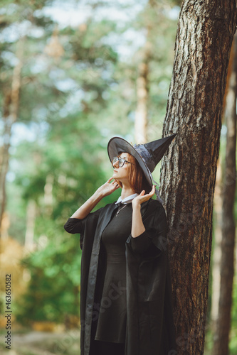 Obraz na płótnie Halloween Witch. Portrait of a girl in a hat and a witch costume in the forest. Ready for trick or treat holiday
w salonie