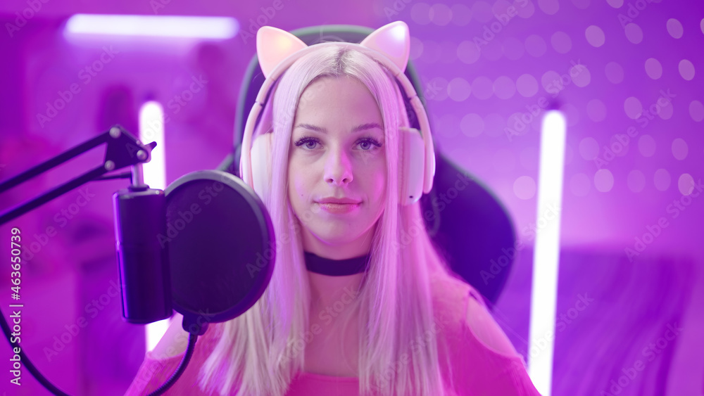 Portrait of Gamer Girl with cat ear headphones in pink room stare in camera Portrait of Gamer Girl with cat ear headphones in pink room stare in camera