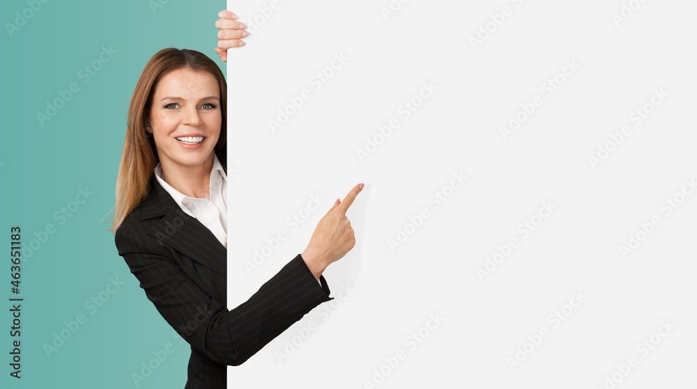 Cheerful Young businesswoman is standing behind the white blank banner advertisement board Cheerful Young businesswoman is standing behind the white blank banner advertisement board