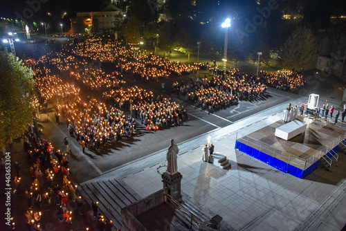 Lourdes, France - 9 Oct 2021: Pilgrims attend the Marian Torchlight Procession service at the Rosary Basilica in Lourdes