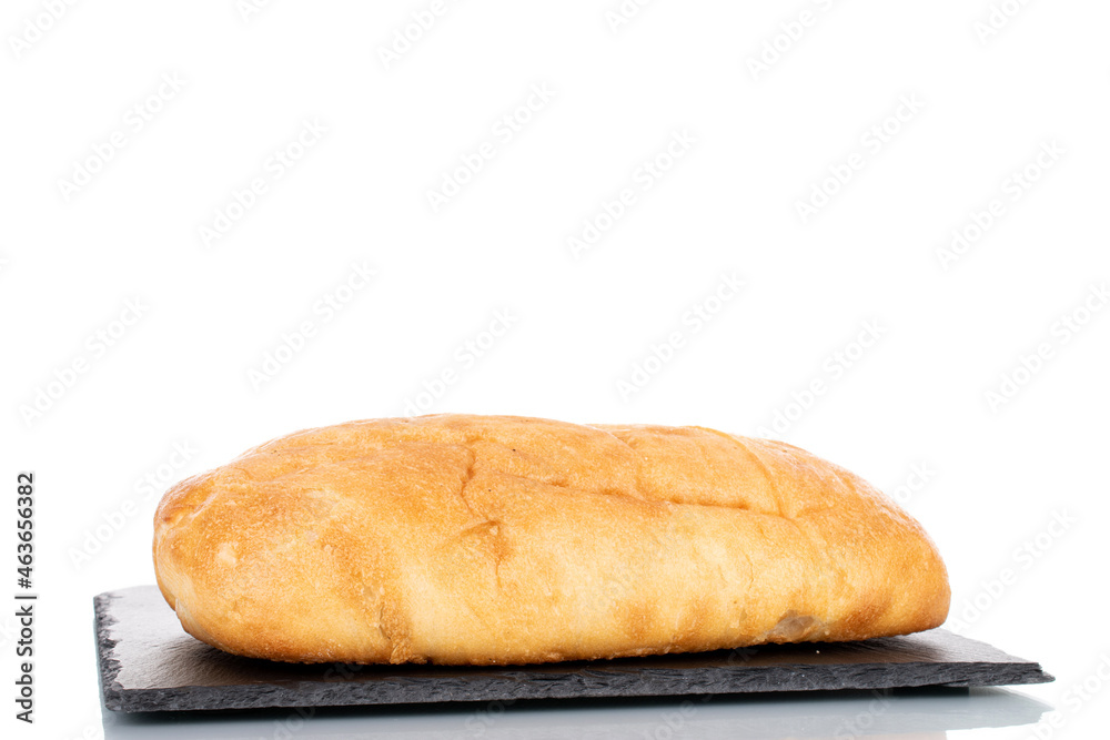 One fragrant ciabatta on a slate stone, close-up, isolated on white.
