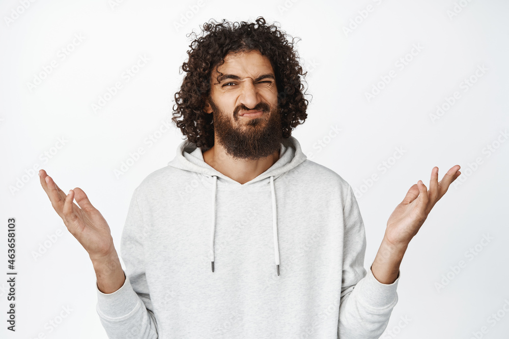 Complicated guy shrugging with spread arms, dont know, looking doubtful and unsure, have no idea, being clueless about smth, white background Complicated guy shrugging with spread arms, dont know, looking doubtful and unsure, have no idea, being clueless about smth, white background