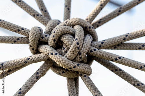 lots of ropes and a big knot against the blue sky