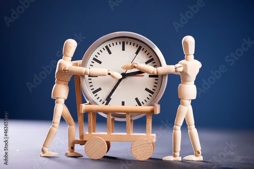 Wooden fugures with clock photo