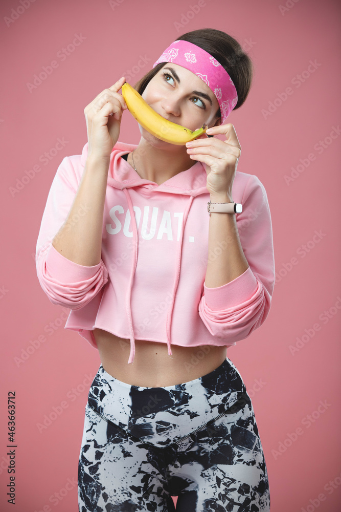 Nice young girl on a diet. On a pink background, the girl holds bananas in her hands. Healthy eating Nice young girl on a diet. On a pink background, the girl holds bananas in her hands. Healthy eating
