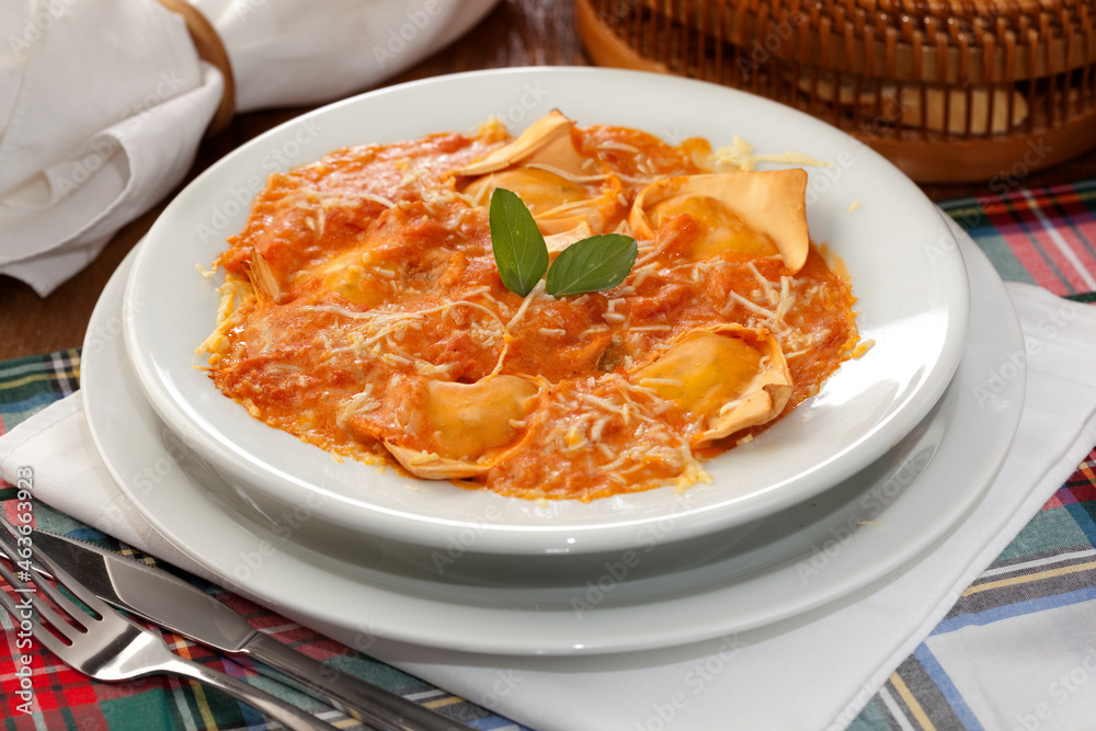 Ravioli, massa italiana, ao molho de tomate, queijo parmesão e folha de manjericão. - obrazy, fototapety, plakaty 