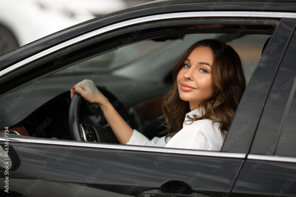 young beautiful woman with makeup driving a car 