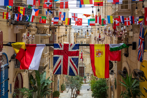 Flags of various countries hanging over one of the streets in Valletta, Malta.