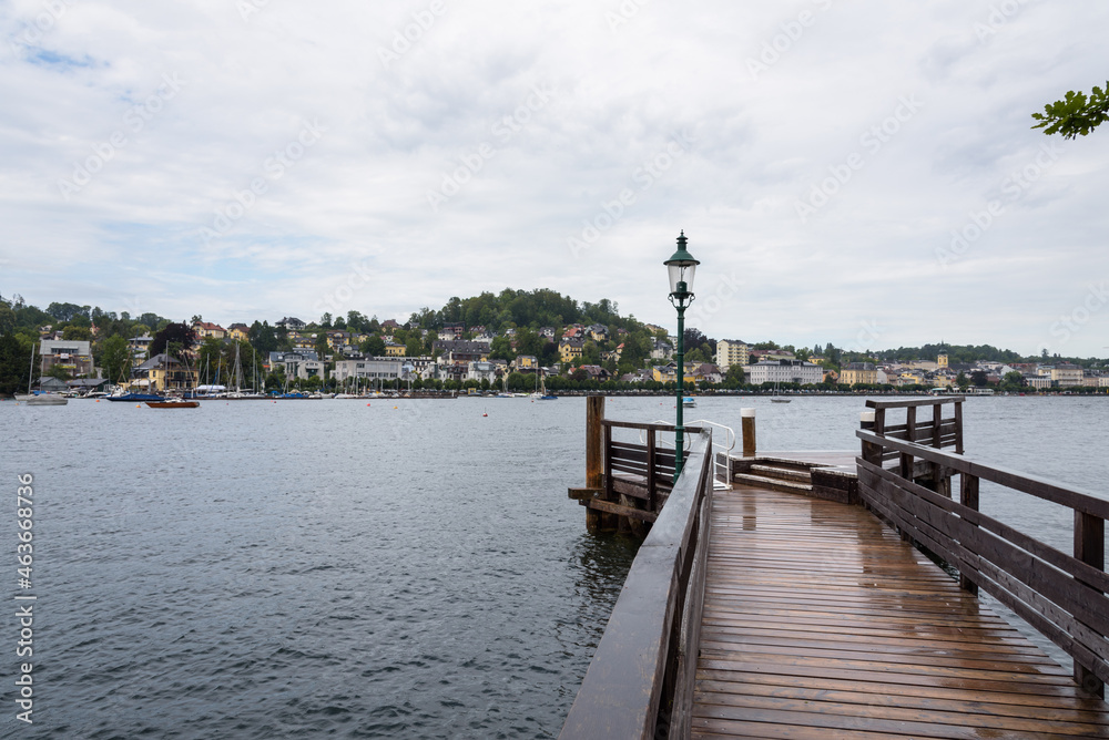 Jetty on a Traunsee lake with the town of Gmuden in the background on a rainy day,Austria