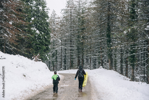 dos personas caminando por un camino de un monte con nieve.  photo