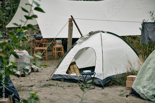 Place of living of migrants or homeless people with group of tents in rural environment