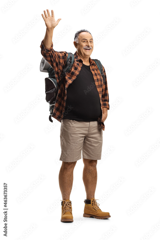 Full length portrait of a mature hiker with a backpack waving at camera Full length portrait of a mature hiker with a backpack waving at camera