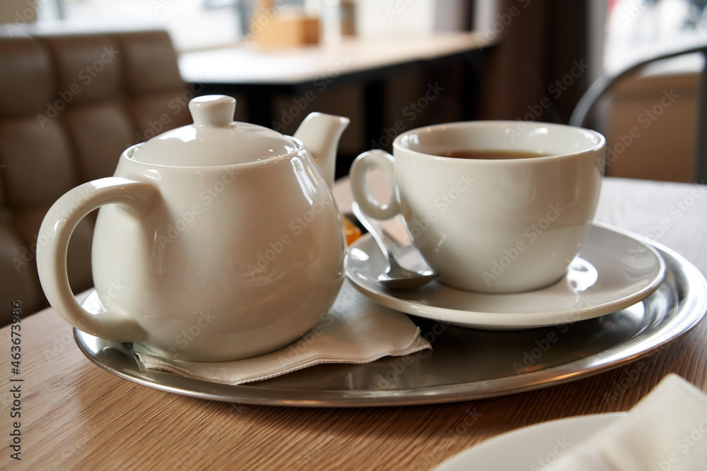 Cup of tea and a teapot inside a cafe