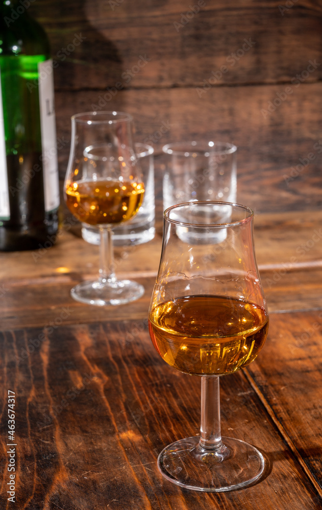 Glasses of strong scotch single malt whisky served on dark wooden table in old pub Glasses of strong scotch single malt whisky served on dark wooden table in old pub