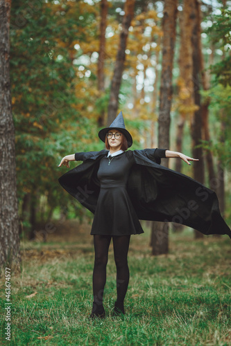 Obraz na płótnie Halloween Witch. Portrait of a girl in a hat and a witch costume in the forest. Ready for trick or treat holiday
w salonie