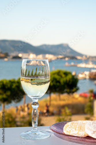 Summer on French Riviera, drinking cold white wine from Cotes de Provence on outdoor terrase with view on harbour of Toulon, Var, France
