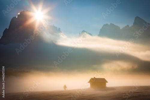 Dolomites mountains with house sunrise - Alpe di Siusi clouds and fog photo