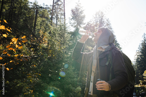 Male hiker is traveling at the mountains with backpacks exploring beautiful places of the natural park enjoying the outstanding landscape views.