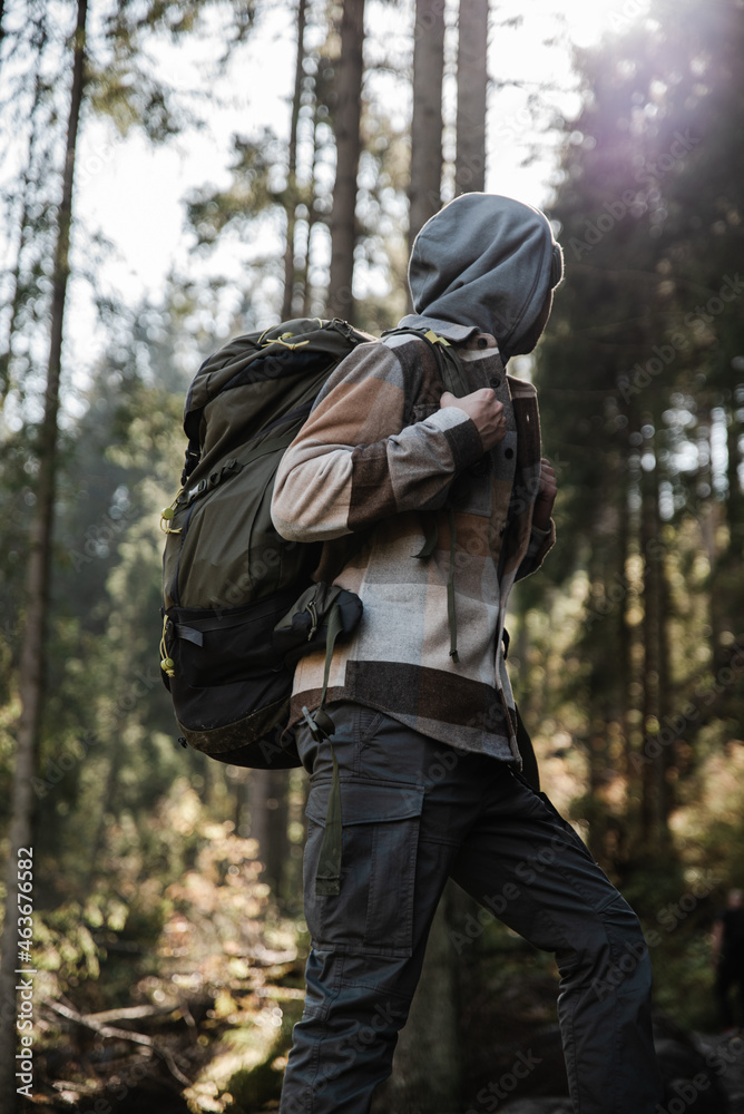 Male hiker is traveling at the mountains with backpacks exploring beautiful places of the natural park enjoying the outstanding landscape views.