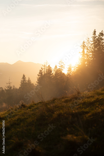 Panoramic wide landscape of mountain range during an autumn sunset with soft golden sunlight through brume in national Tatra National Park Poland.