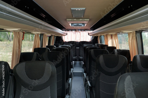 Long aisle surrounded by two rows of comfortable double seats inside contemporary passenger transport