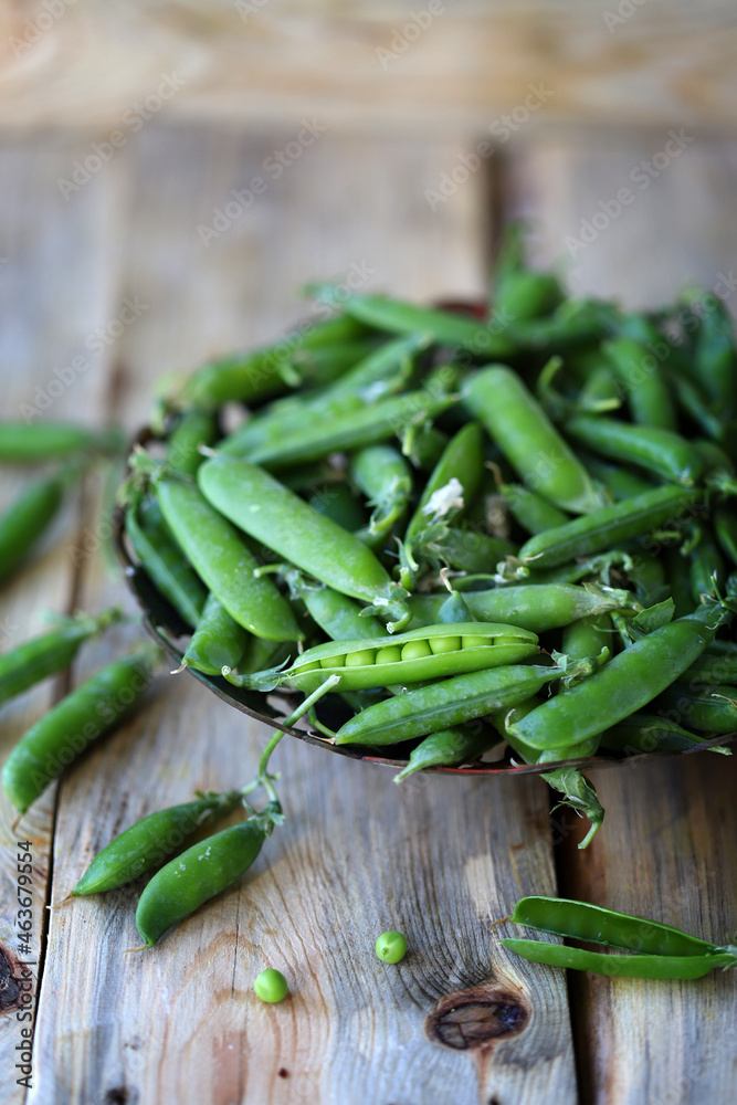 Fresh green peas in a peel on a wooden surface. Fresh green peas in a peel on a wooden surface.
