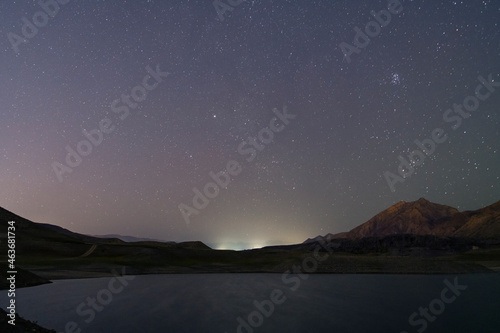 Beautiful night landscape. Small lake and mountains under starry sky. © Inga Av