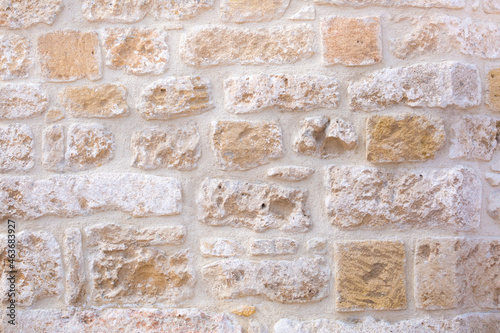 Stone antique old wall as a background or texture. Vintage background of a fortress wall in loft and grunge style with place for text and copy space.