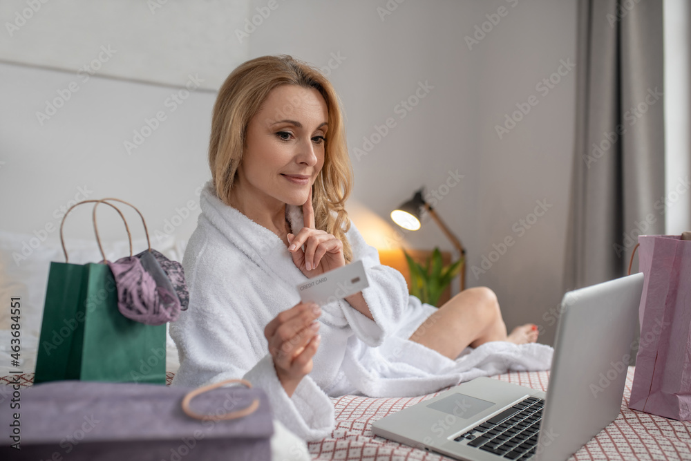 Charming woman with credit card looking into laptop Charming woman with credit card looking into laptop