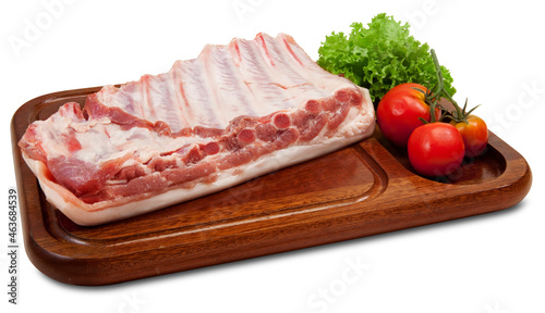 Costelinha de porco crua na tábua de madeira em fundo branco para recorte.