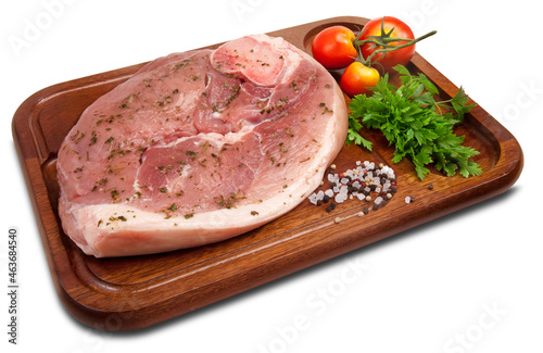 Fatia grossa de pernil cru e temperado na tábua de  madeira em fundo branco para recorte.