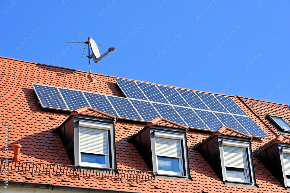 Fototapeta premium Photovoltaikanlage auf rotem Hausdach, mit SAT-Antenne