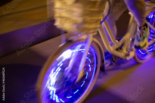 Man riding bicycle with purple lights at night