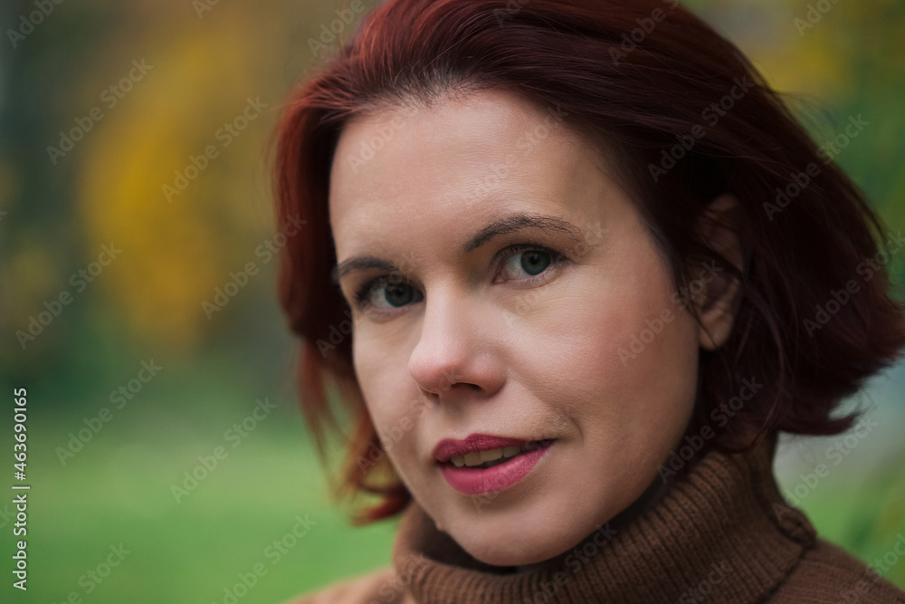Portrait Of A Mature Woman against yellow forest trees in the autumn Portrait Of A Mature Woman against yellow forest trees in the autumn