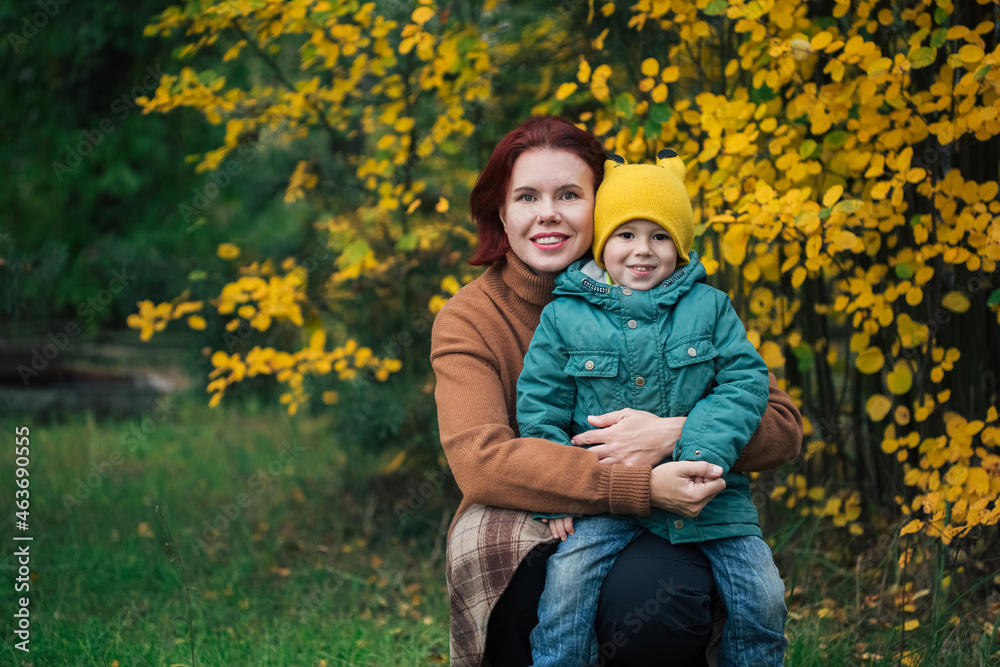 Little caucasian boy and his mother against yellow autumn forest Little caucasian boy and his mother against yellow autumn forest