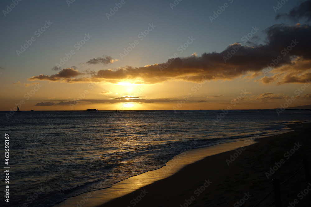 Orange Sunset with purple clouds over a scenic view of the Pacific Ocean off the coast of Waikiki Beach in Hawaii