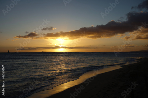 Orange Sunset with purple clouds over a scenic view of the Pacific Ocean off the coast of Waikiki Beach in Hawaii