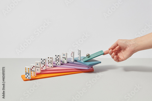 Woman pushing sphere on dominoes photo