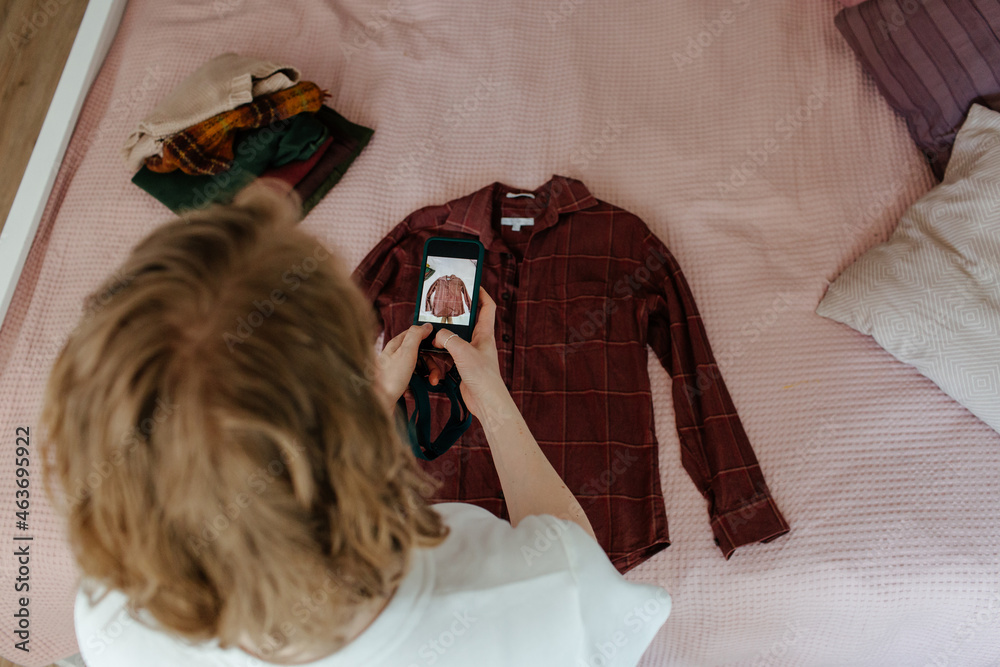 © Sergey Narevskih/Stocksy - Woman taking photo of clothes © Sergey Narevskih/Stocksy - Woman taking photo of clothes