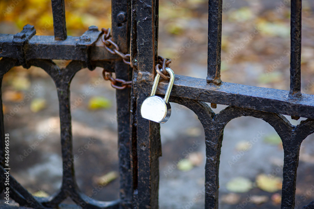 Antique lattice gates closed on a chain with a padlock. The passage is closed. Antique lattice gates closed on a chain with a padlock. The passage is closed.