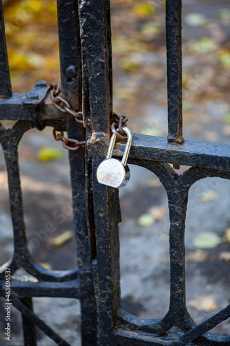 Antique lattice gates closed on a chain with a padlock. The passage is closed.