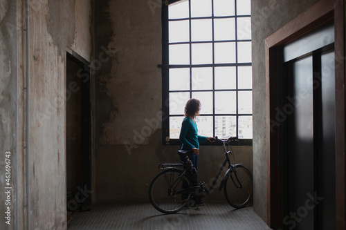 Woman put yours hands together next to a window photo