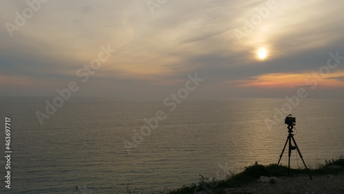 Camera taking picture of sunset over sea
